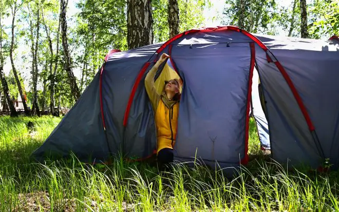 A girl sets up a camping tent during her stay in nature