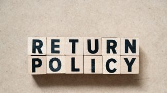 Alphabet letter block in word return policy on wood background