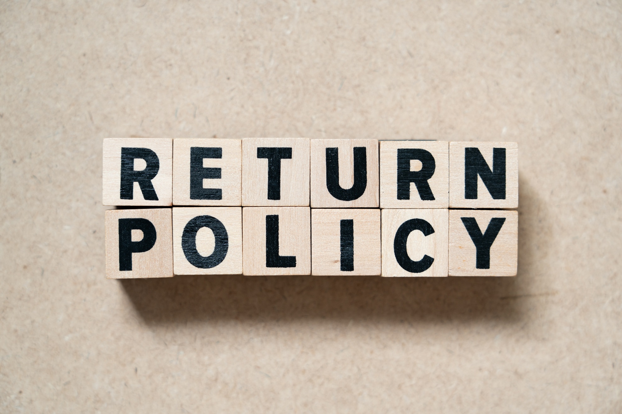 Alphabet letter block in word return policy on wood background