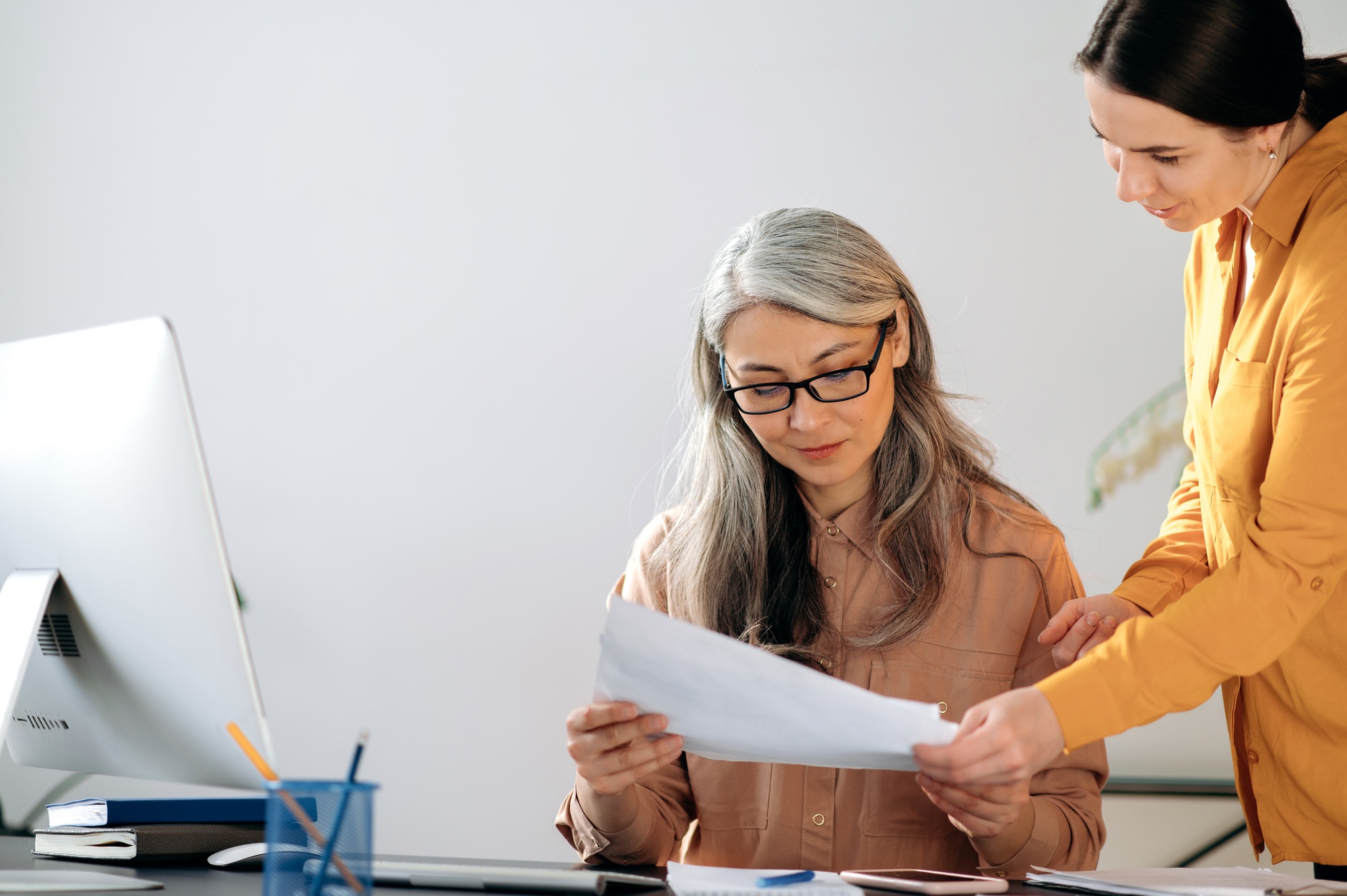 Asian senior woman with glasses, business woman, desk, smiling, documents