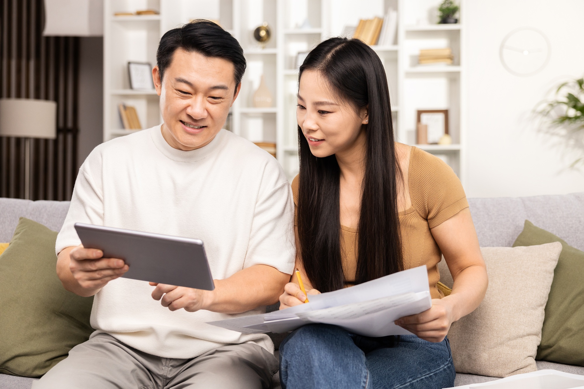 Couple Planning Budget with Tablet and Documents at Home