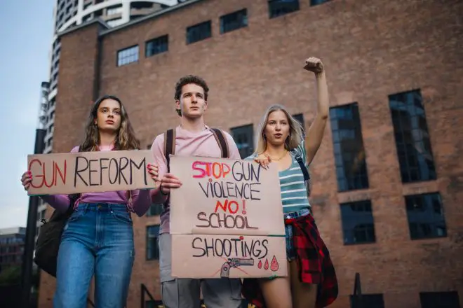 Generation Z activists with banners protesting on the street.