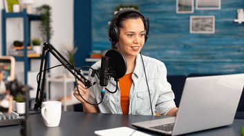 Prosperous female leader of working team holds digital tablet device, develops business ideas