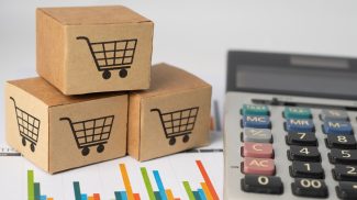 Shopping cart logo on box with calculator on graph background.